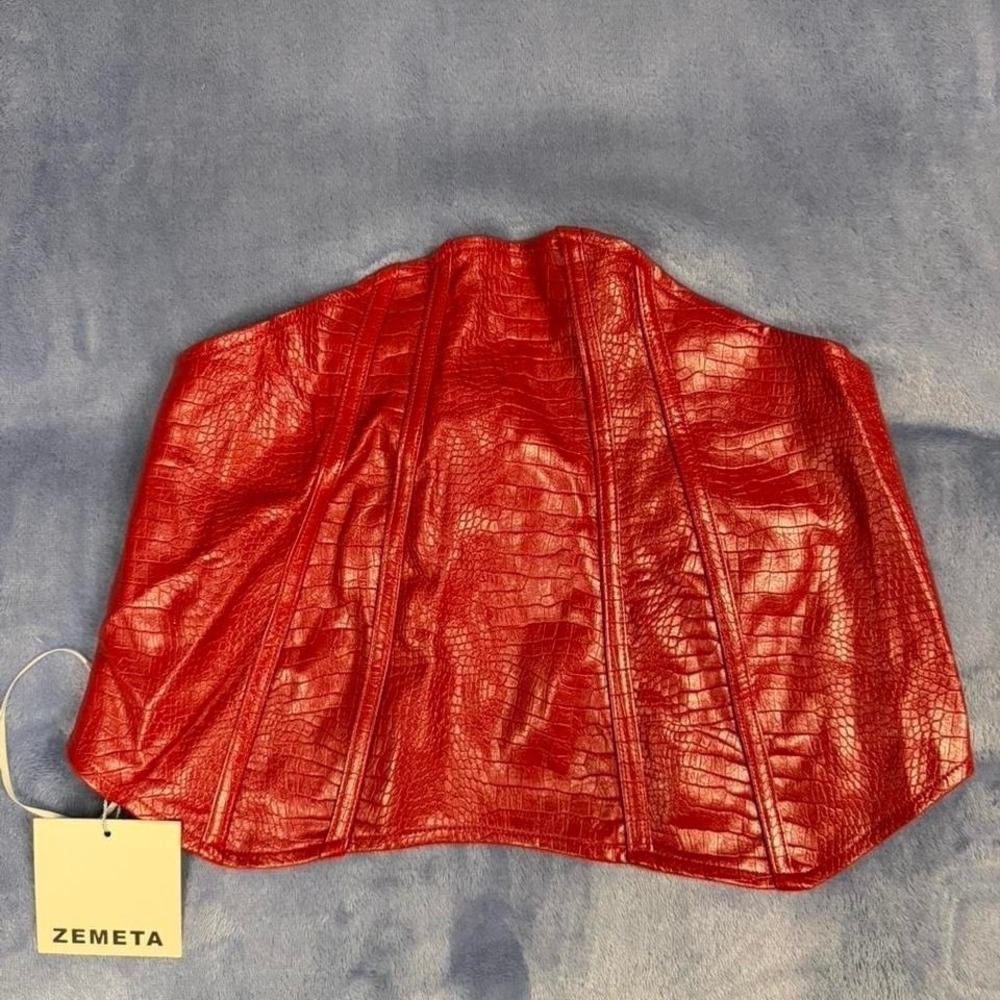 Red faux leather corset top with zipper closure and adjustable straps. Size:‎ S